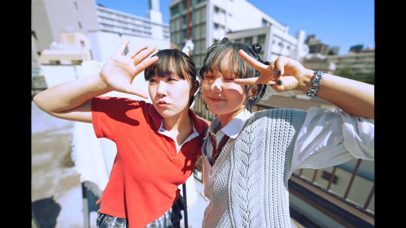 Two dancers on a rooftop in daylight